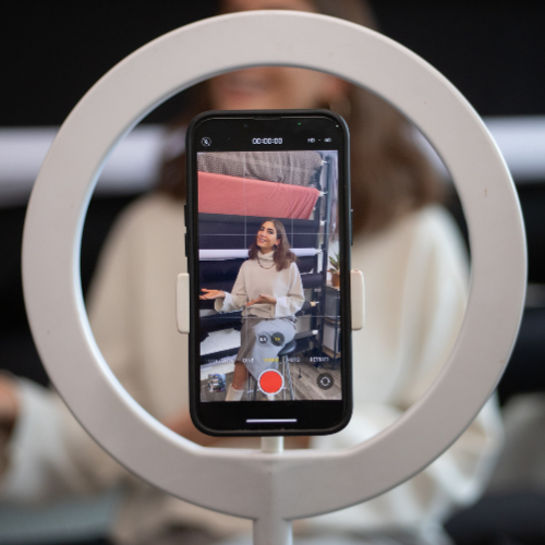 Content creator recording a personal branding video with smartphone and ring light – visual branding and digital storytelling setup