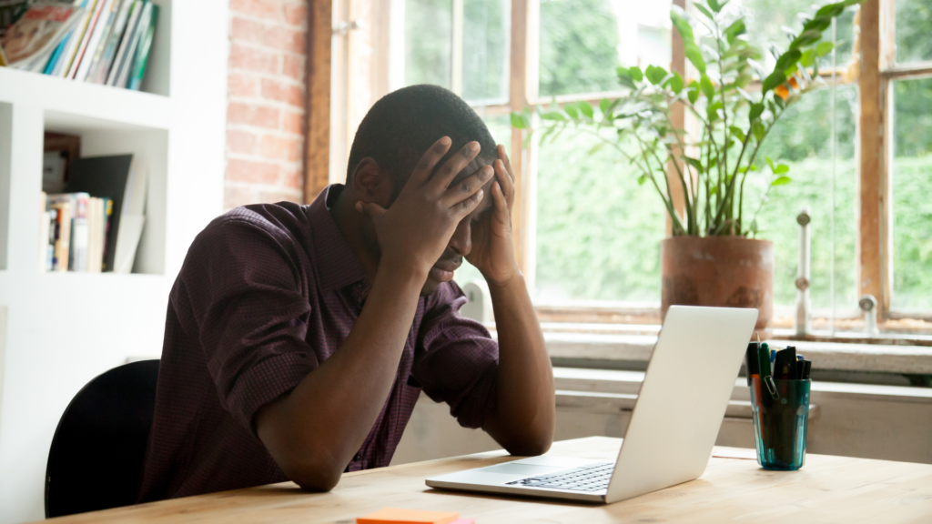 A frustrated business owner sitting at a laptop looking at a website analytics dashboard with little or no enquiries